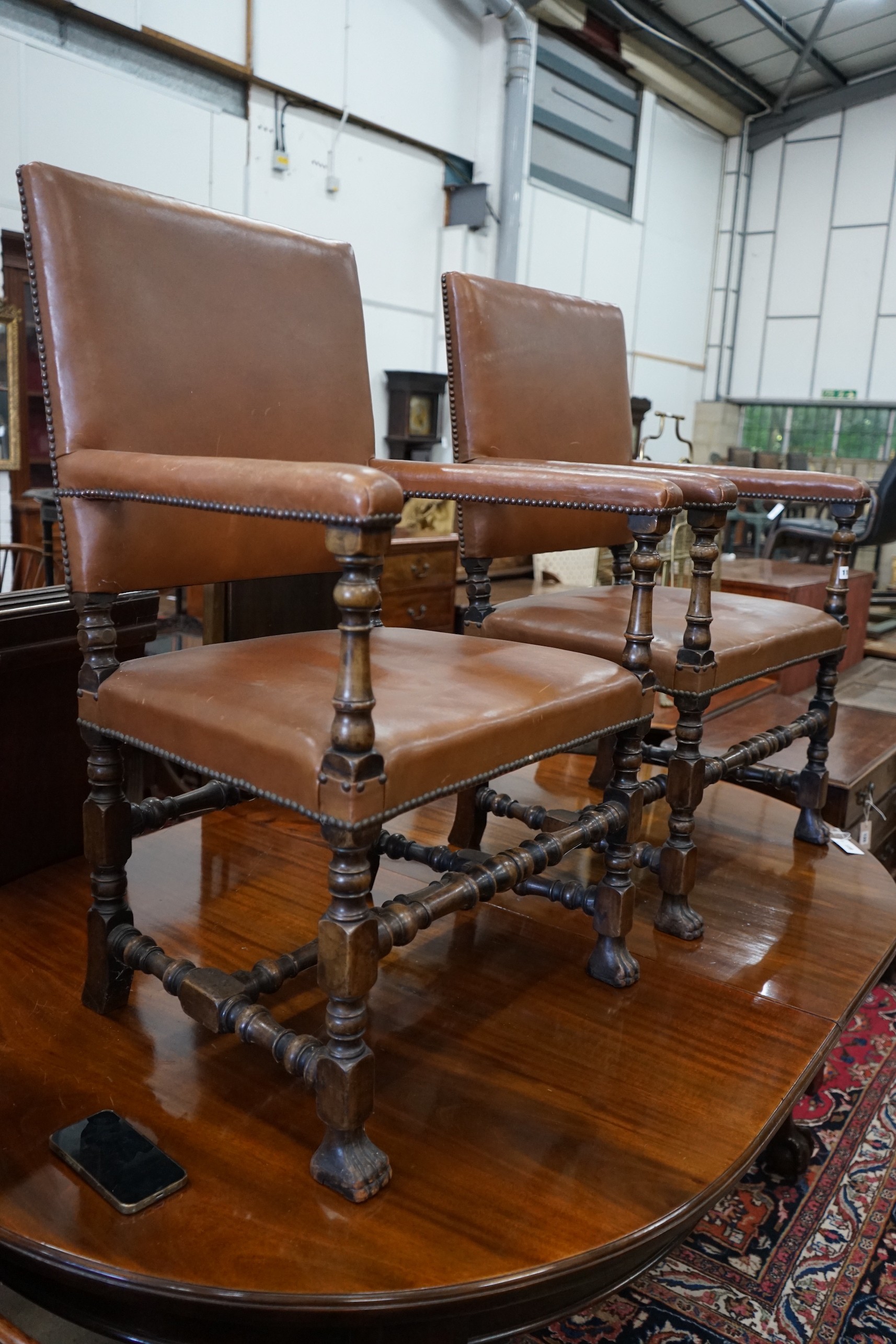 A pair of 1920's Carolean style walnut elbow chairs, width 62cm, depth 47cm, height 100cm